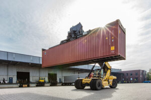 reachstacker hebt container auf der rückseite des pch packing center hamburg über den hof hyster