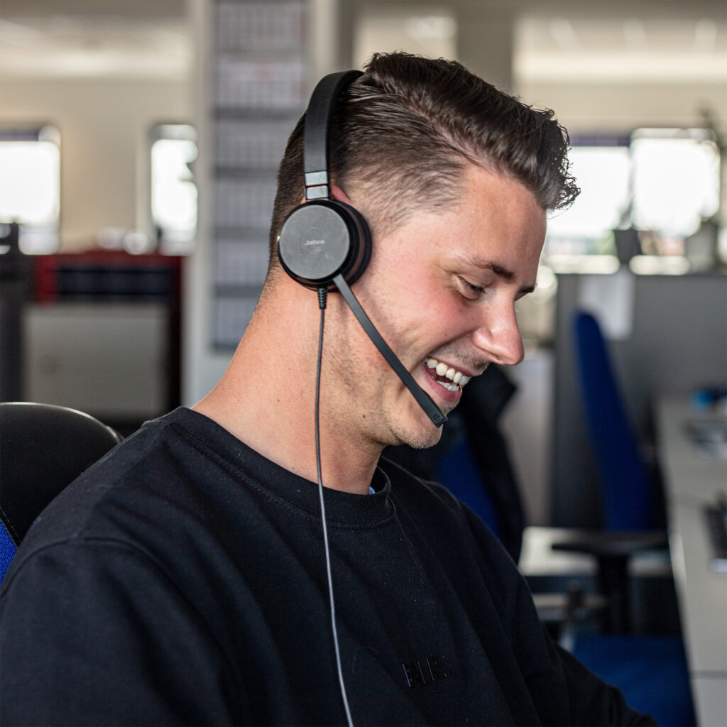 SACO Kollege mit Headset am telefonieren