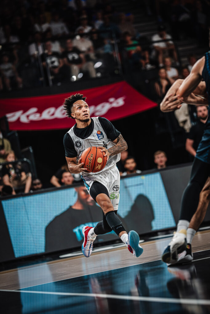 Spieler Jaizec Lottie rennt auf dem Spielfeld mit dem Basketball in der Hand